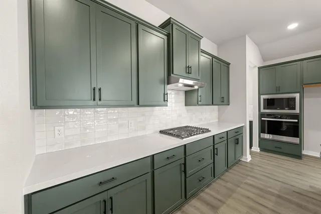 a kitchen with stainless steel appliances granite countertop a sink and stove top oven