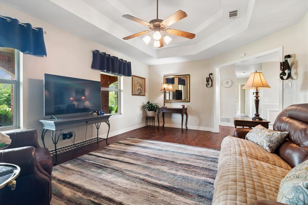 8463 Crestview Road Sanger, TX 76266 - Photo 13 of 36 Living room featuring a raised ceiling, a ceiling fan, and dark wood-type flooring