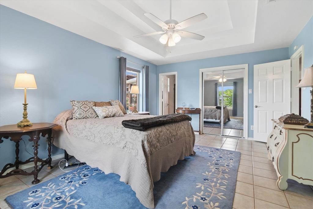 8463 Crestview Road Sanger, TX 76266 - Photo 17 of 36 Bedroom featuring light tile patterned flooring, a raised ceiling, a closet, and a ceiling fan