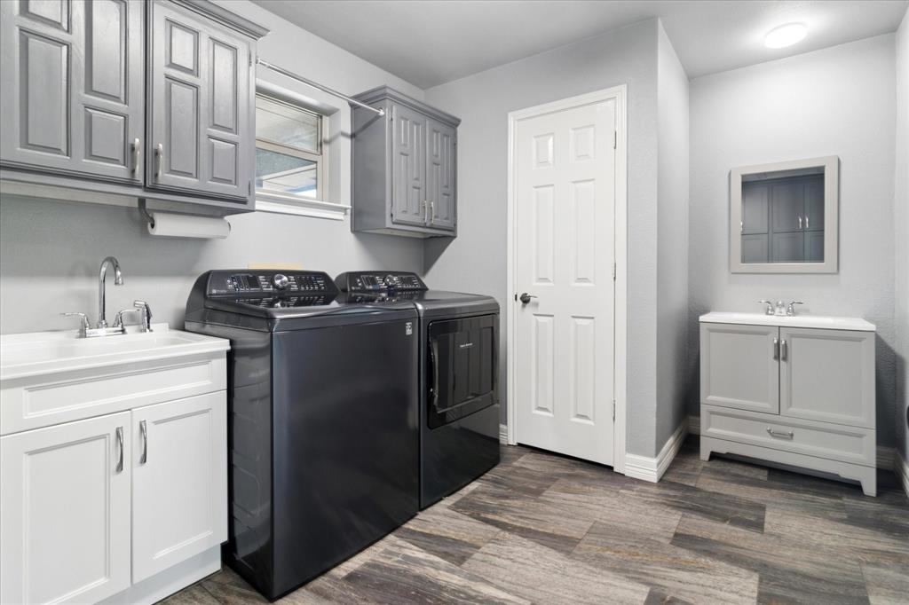 8463 Crestview Road Sanger, TX 76266 - Photo 21 of 36 Laundry area with cabinet space, washer and clothes dryer, and dark wood finished floors