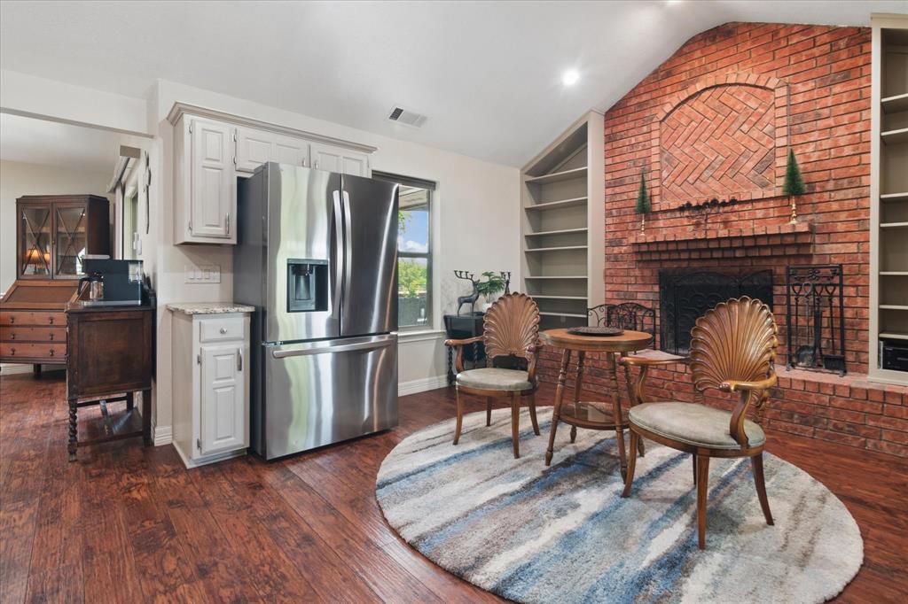 8463 Crestview Road Sanger, TX 76266 - Photo 9 of 36 Kitchen featuring stainless steel fridge, built in features, dark wood-style flooring, and a brick fireplace