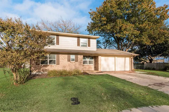 a front view of a house with a garden and trees
