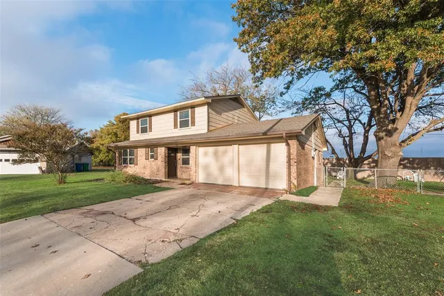 a front view of a house with a yard and trees