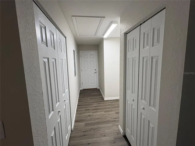 an empty room with closet and a chandelier fan