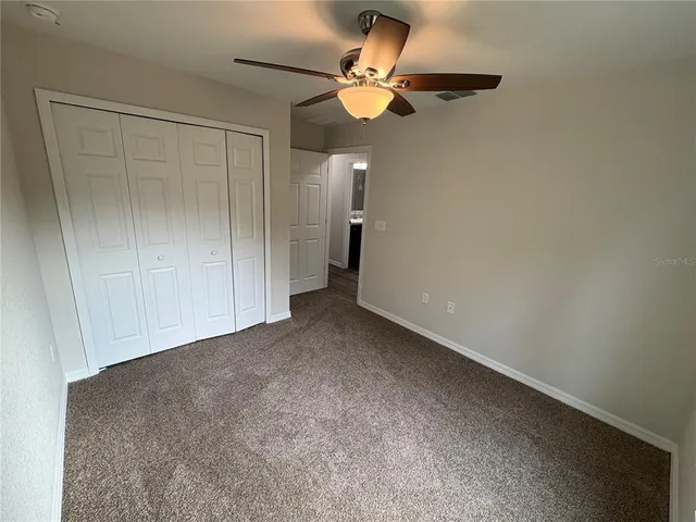 an empty room with a window and a fan