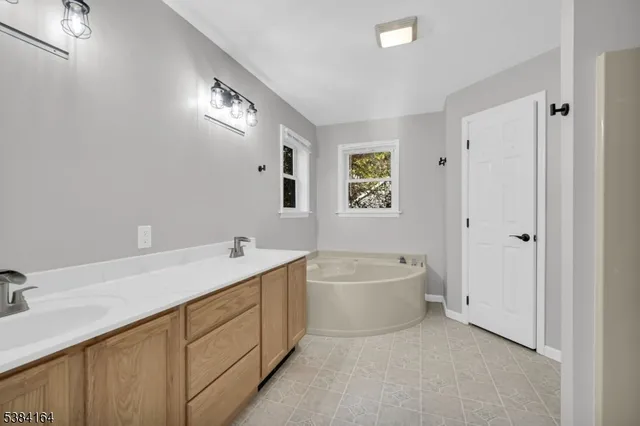 a bathroom with a tub a sink and mirror