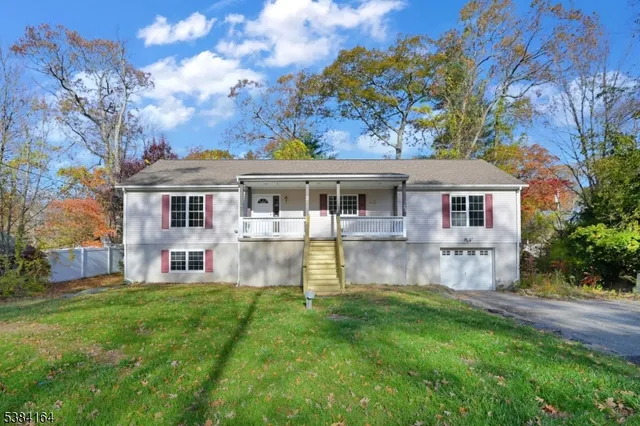 a view of a house with a yard and a large tree