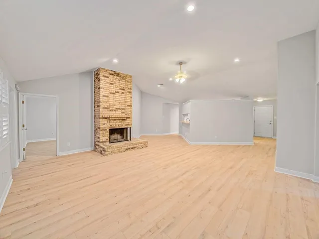 a view of an empty room with a window and fireplace