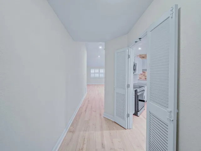 a view of a hallway with wooden floor