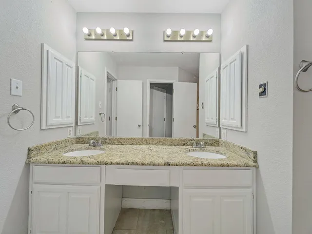 a bathroom with a granite countertop sink and a mirror