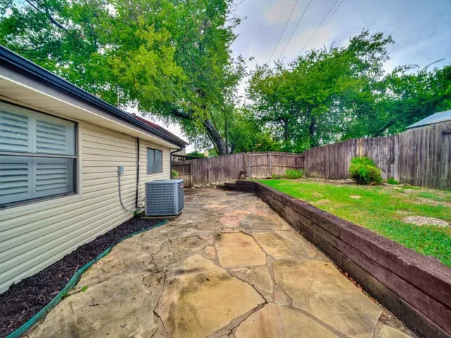 a view of backyard with potted plants and wooden fence