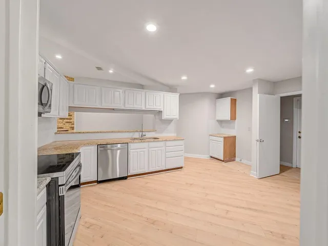 a kitchen with a refrigerator sink and cabinets