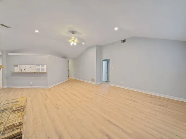 a big room with wooden floor and a ceiling fan