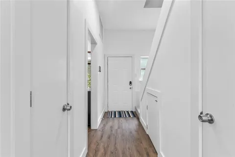 a view of a hallway with wooden floor and staircase