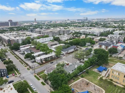 an aerial view of a city with lots of residential buildings ocean and mountain view in back