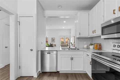 a kitchen with white cabinets and white appliances