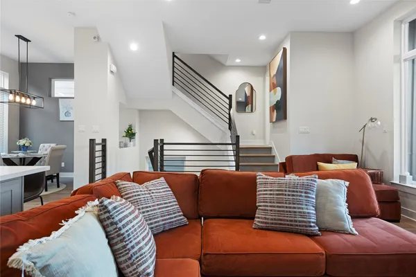 a living room with furniture kitchen view and a potted plant