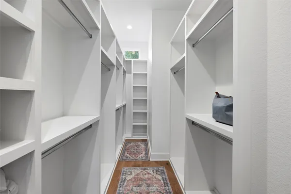 a spacious bathroom with double sink a large mirror and shower