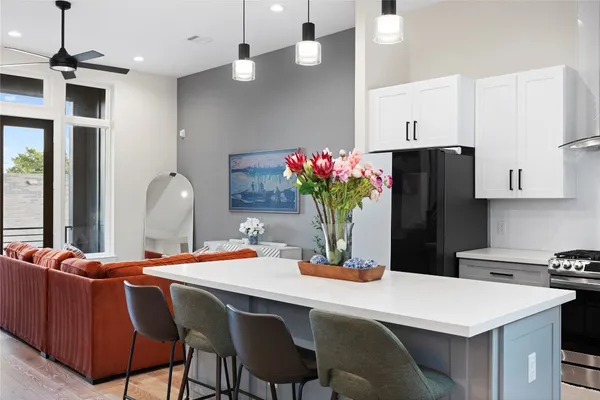 a dining room with stainless steel appliances kitchen island granite countertop a dining table and chairs