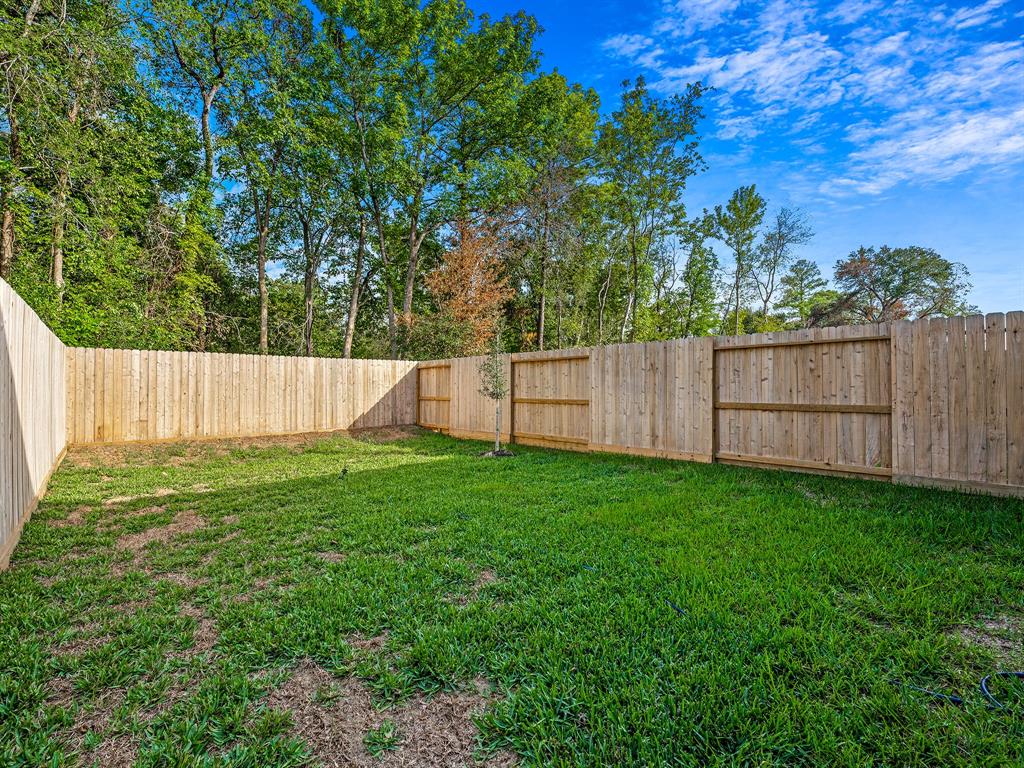 a view of backyard with wooden fence