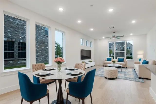 a living room with furniture kitchen view and a large window