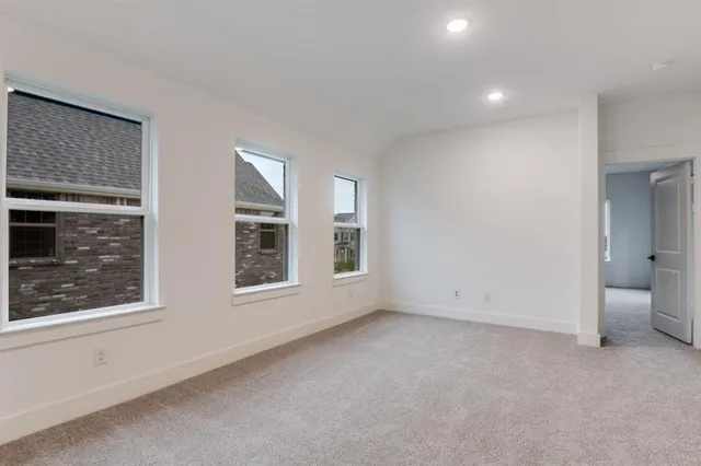 a view of an empty room with a window and bathroom