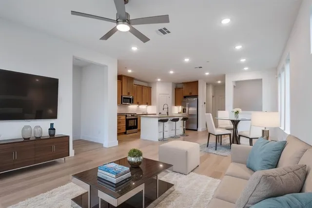 a living room with furniture kitchen view and a flat screen tv