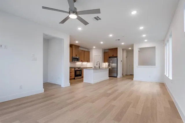a view of kitchen with kitchen island wooden floor center island and appliances