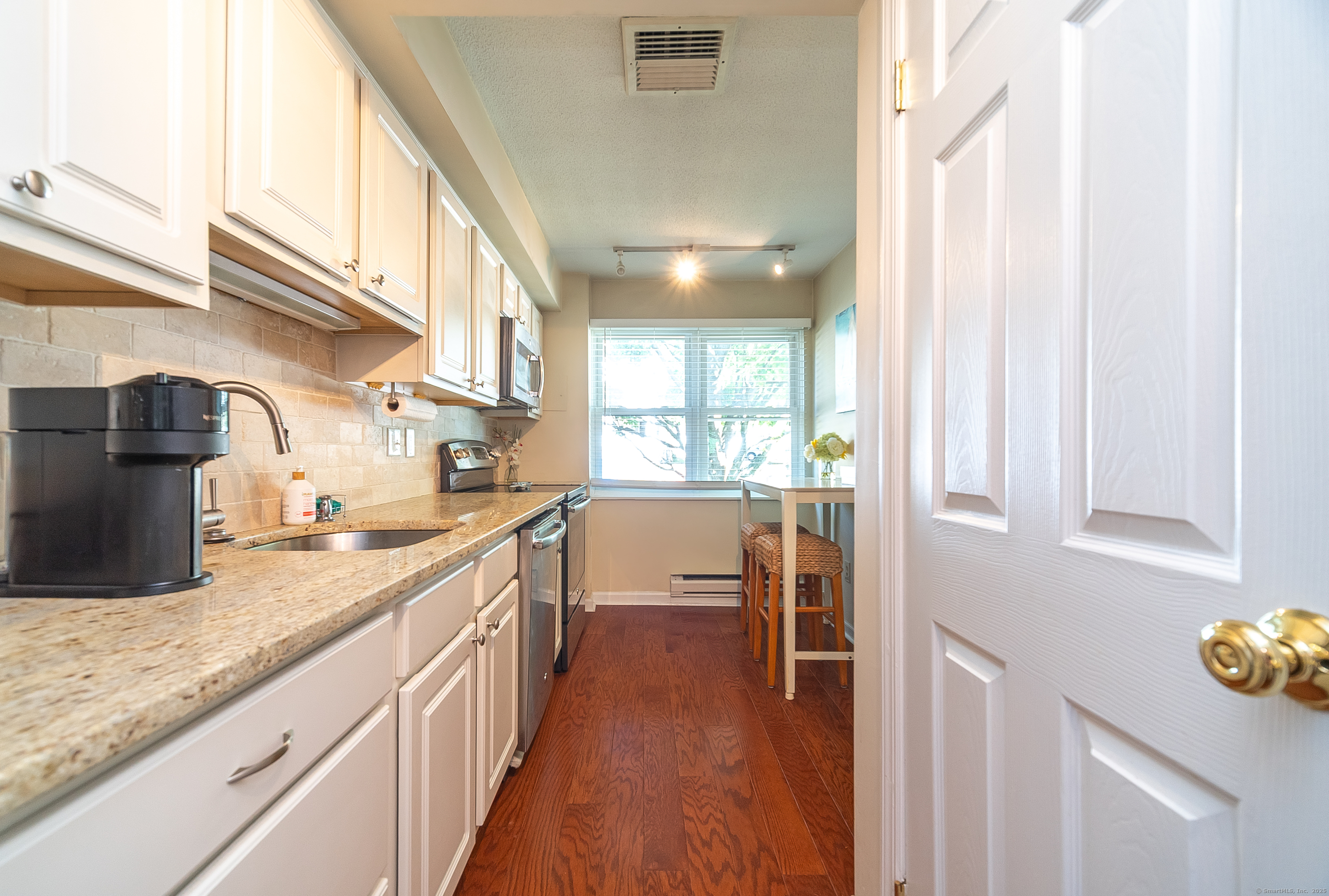 109 Highland Road, Unit 109 Stamford, CT 06901 - Photo 20 of 37 a kitchen with sink cabinets and wooden floor