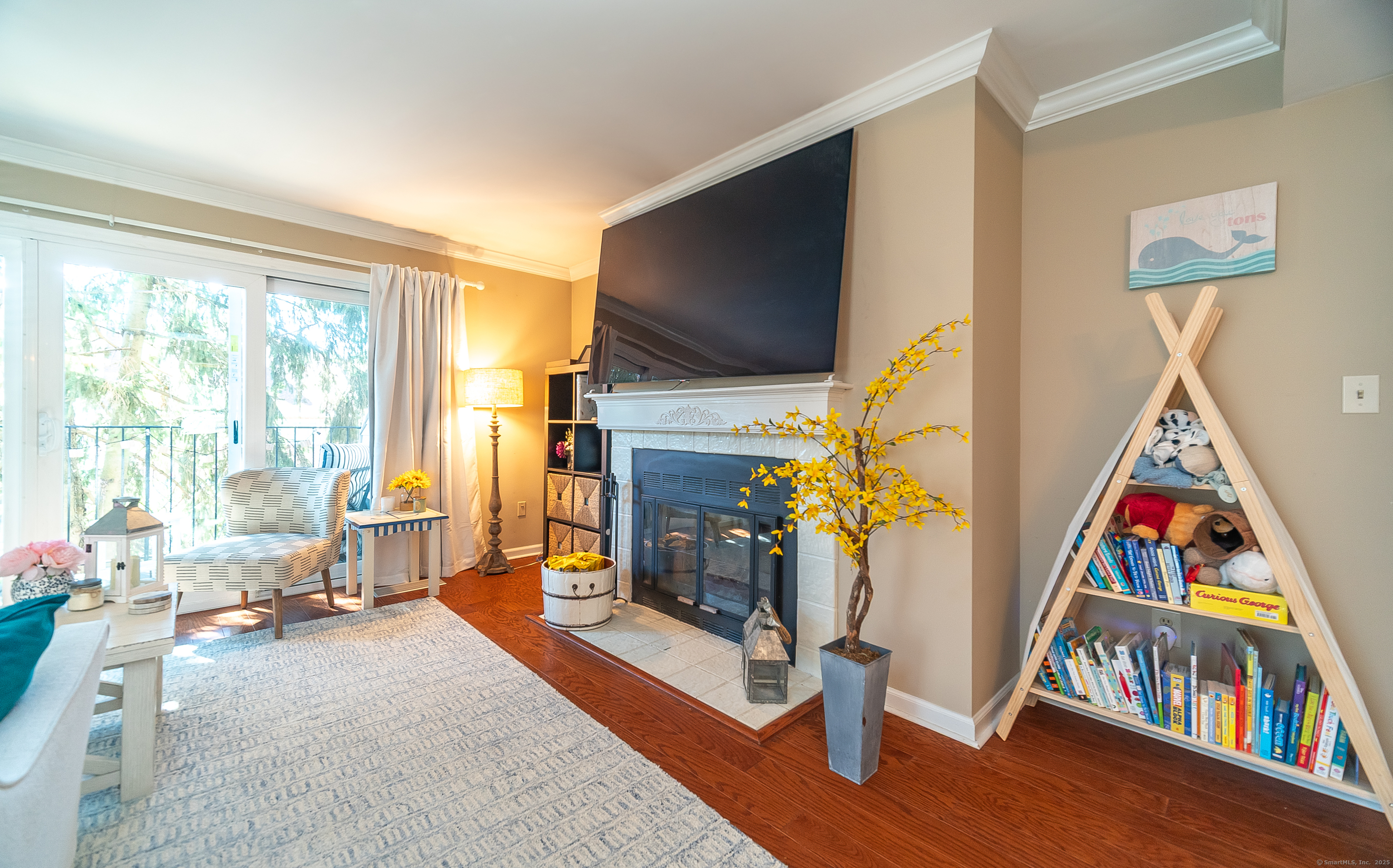109 Highland Road, Unit 109 Stamford, CT 06901 - Photo 24 of 37 a living room with furniture flat screen tv and a fireplace