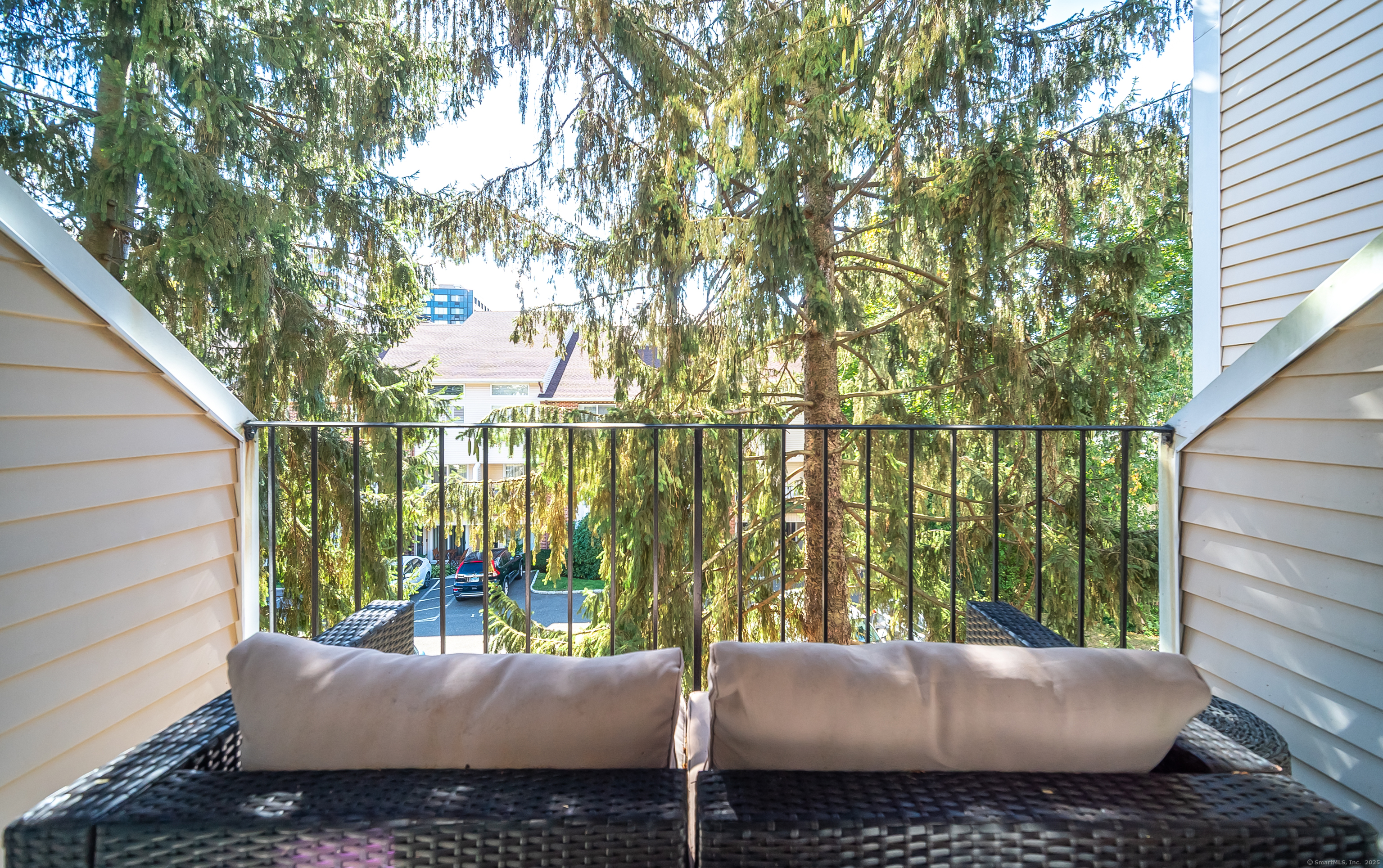 109 Highland Road, Unit 109 Stamford, CT 06901 - Photo 31 of 37 a view of a patio with couches and table and chairs with wooden fence and floor