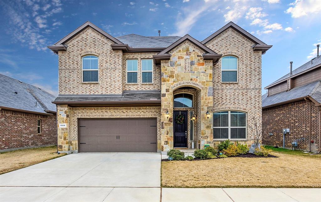 a front view of a house with yard and parking