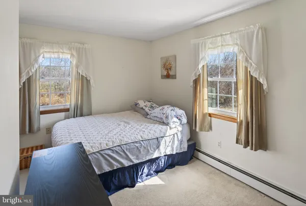 a bedroom with a bed next to a window