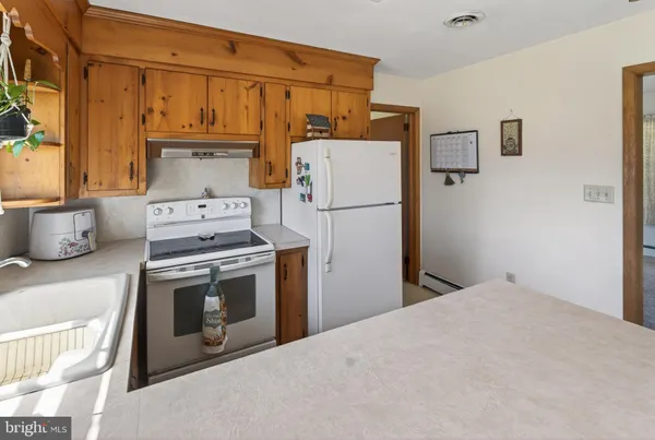 a kitchen with a refrigerator stove and white cabinets