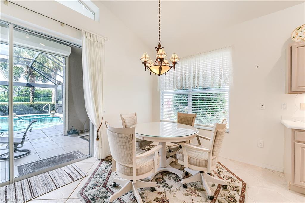 9156 Spring Run Boulevard Estero, FL 34135 - Photo 9 of 34 a dining room with wooden floor a glass table and chairs