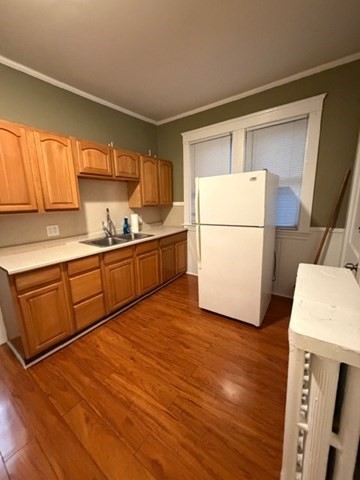 a kitchen with sink a refrigerator and white cabinets