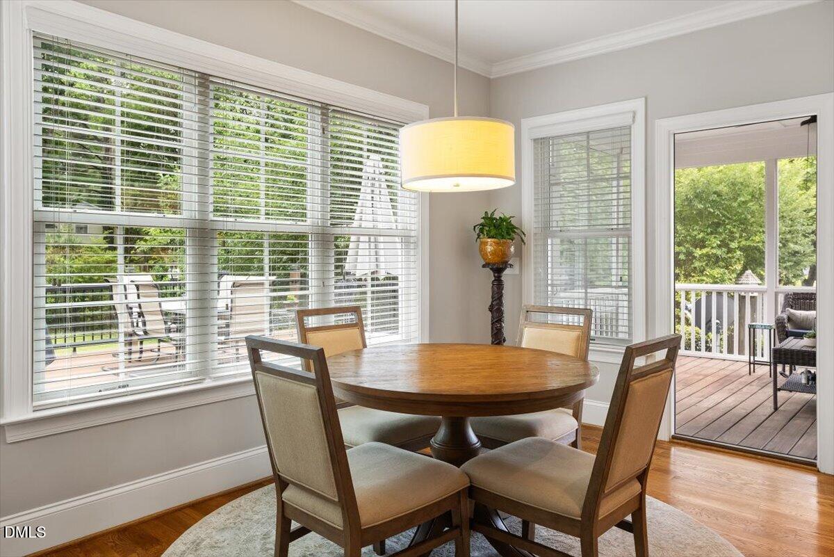 1404 Ivy Lane Raleigh, NC 27609 - Photo 7 of 37 Hardwood flooring, crown molding, large window, drum pendant light, and direct access to a screened porch