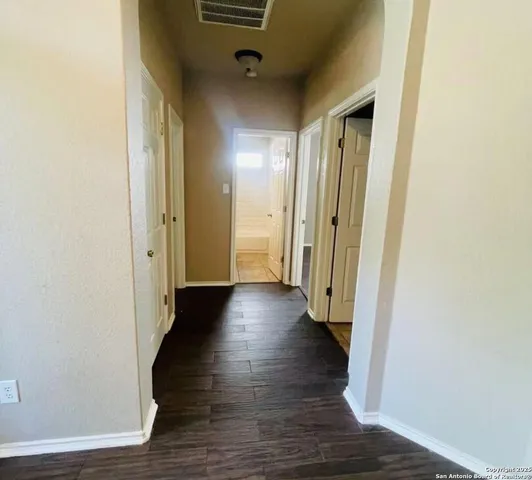 a view of a hallway with wooden floor