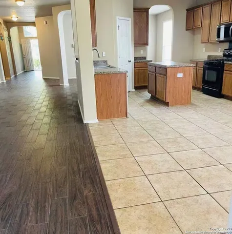 a large kitchen with stainless steel appliances a stove a sink and a refrigerator