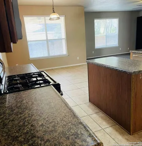 a kitchen with a stove a window and a counter top space