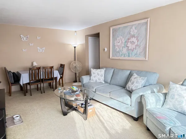 a living room with furniture and a dining table with kitchen view