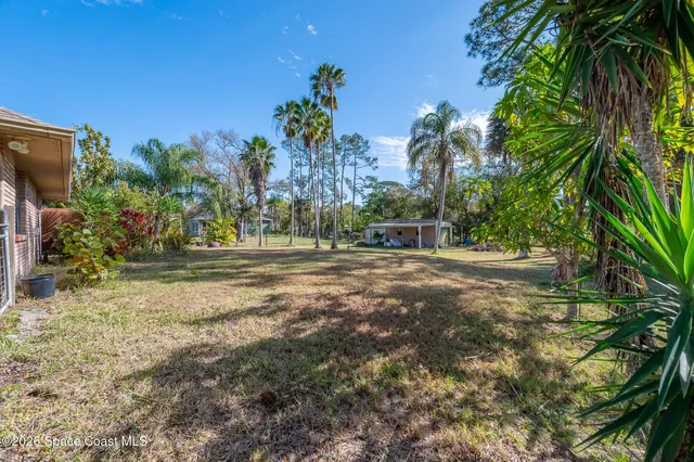 a view of a house with backyard sitting area and garden
