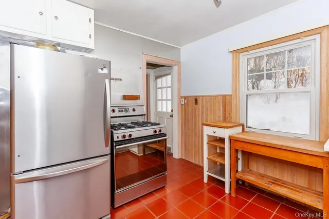 a kitchen with white cabinets and a refrigerator