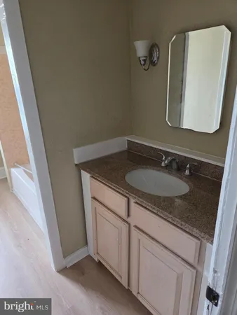 a bathroom with a granite countertop sink and a mirror