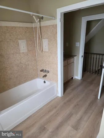 a bathroom with a tub shower vanity and a sink