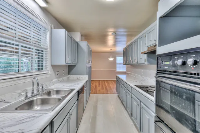 a kitchen with a sink stove top oven and cabinets