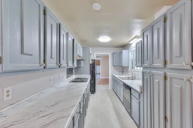 a kitchen with granite countertop a sink stove and cabinets