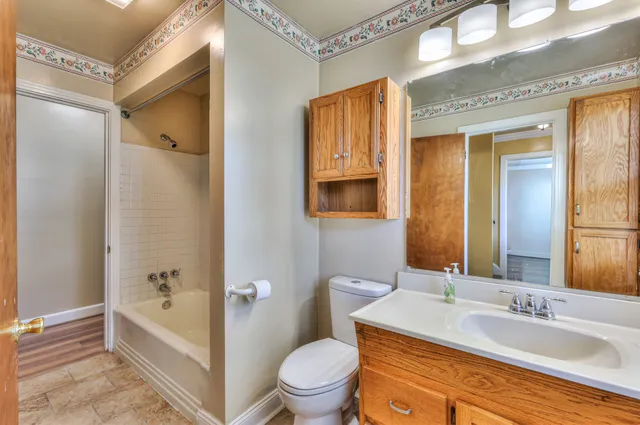 a bathroom with a granite countertop sink toilet and shower