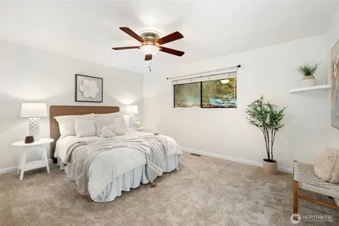 a spacious bedroom that has a bed and a potted plant