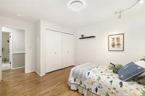 a bedroom with bed and wooden floor